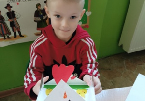 Chłopiec z grupy 2 wykonuje kartkę wielkanocną.