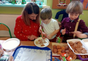 Chłopcy z grupy 9 wraz z mamą dekorują pierniki