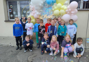 Zdjęcie grupy przedszkolnej na tle ścianki z balonami