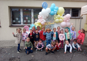 Zdjęcie grupy przedszkolnej na tle ścianki z balonami
