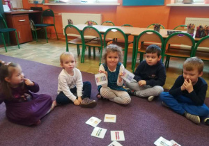 Dzieci łączą w pary kartoniki z tymi samymi kredkami.