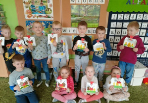 Wspólne zdjęcie dzieci z grupy 2 z wykonanymi kartkami wielkanocnymi.