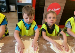 Chłopcy z grupy 2 wykonujący ciasto na pizzę.