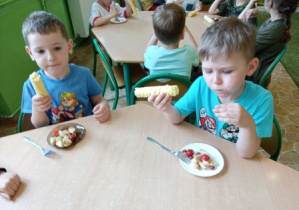 Dzieci z grupy 2 spożywają sałatkę owocową.