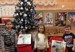 Dzieci z grupy 8 rozpakowują prezenty od Świętego Mikołaja.