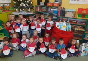 Wspólne zdjęcie dzieci z grupy 5 z prezentami od Świętego Mikołaja.