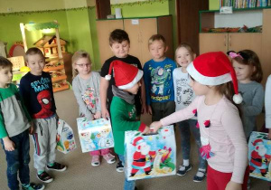 Dzieci z grupy 7 otrzymują prezenty od Świętego Mikołaja.