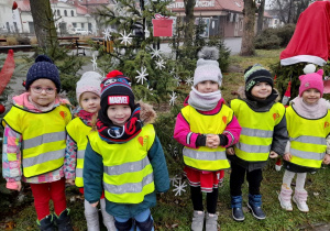 Dzieci z grupy 4 przy udekorowanej choince w Aleksandrowskiej Alei Bożonarodzeniowej