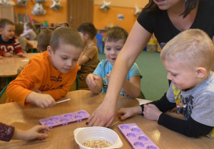 Dzieci z grupy 6 wraz z zaproszoną mamą przygotowują lizaki podczas warszatów