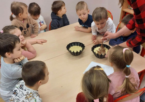 Dzieci z panią wychowawczynią w trakcie robienia ciasta