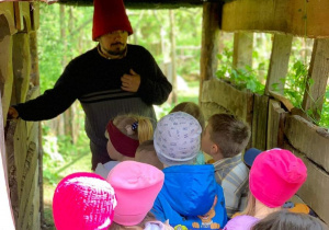 Przedszkolaki słuchają opowieści Skrzatologa w trakcie zwiedzania Doliny Skrzatów