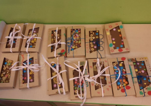 kolorowe czekolady, spakowane w udekorowane przez dzieci pudełka