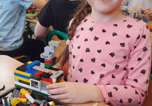 Dziewczynka buduje z klocków LEGO