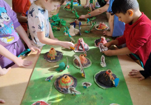 Dzieci w trakcie tworzenia makiety przedstawiającej park jurajski