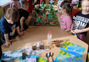 Dzieci przygotowują się do eksperymentu: wulkanu z wody, sody i octu