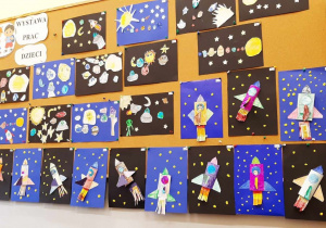Prace plastyczne wykonane przez dzieci: kosmos oraz rakiety na ciemnym tle