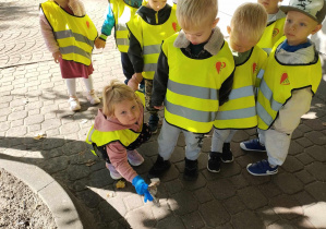 Dzieci z grupy 6 sprzątają śmieci poza terenem przedszkola.