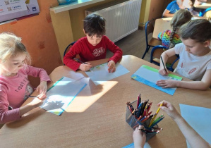 Dzieci robiące pracę plastyczną przy stoliku