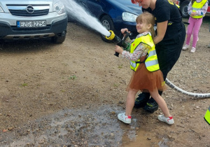 Lanie wody przez przedszkolaka za pomocą węża strażackiego