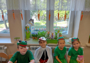 Reprezentacja grupy przedszkolnej siedząca przy stoliku w sali