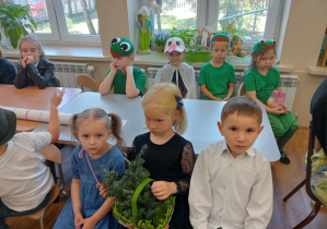Uczestnicy konkursu siedzący przy stoliku w sali przedszkolnej