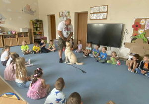 Dzieci patrzą na psa robiącego sztuczki