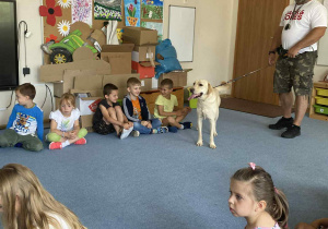 Dzieci patrzą na psa robiącego sztuczki