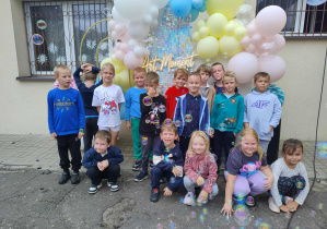 Zdjęcie grupy przedszkolnej na tle ścianki z balonami