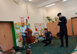 Muzycy gają na instrumentach muzycznych przed dziećmi