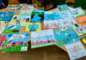 Zdjęcie przedstawia wszystkie prace konkursowe leżące na stolikach w sali przedszkolnej