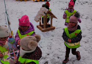 Dzieci sypiące karmę do karmika