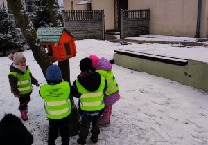 Dzieci sypiące karmę do karmika