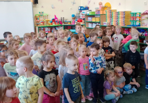 Grupa muzyków wraz z tancerką występująca w sali przedszkolnej przed dziećmi