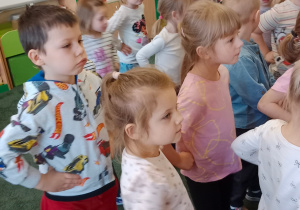 Dzieci tańczące w sali przedszkolnej podczas występu artystów