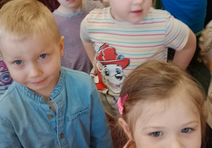 Dzieci tańczące w sali przedszkolnej podczas występu artystów