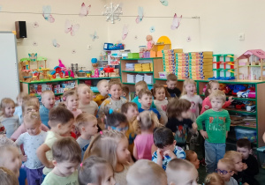 Dzieci tańczące w sali przedszkolnej podczas występu artystów