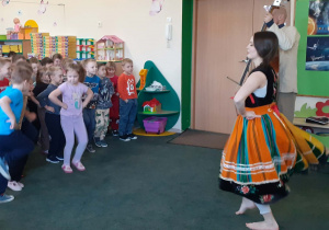 Dzieci tańczące w sali przedszkolnej podczas występu artystów