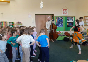 Dzieci tańczące w sali przedszkolnej podczas występu artystów