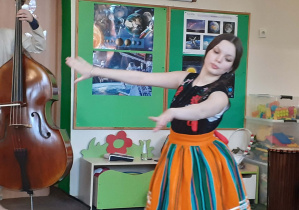 Tancerka ubrana w tradycyjny strój ludowy występująca przed dziećmi