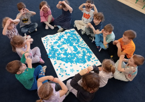 Grupa dzieci prezentująca wspólna pracę plastyczną.