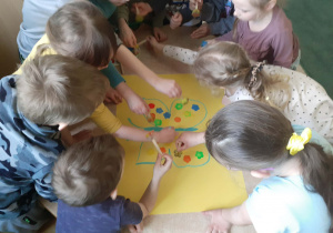 Grupa dzieci prezentująca wspólna pracę plastyczną.