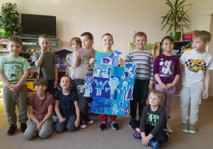 Grupa dzieci prezentująca wspólna pracę plastyczną.