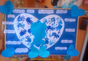 Grupa dzieci prezentująca wspólna pracę plastyczną.