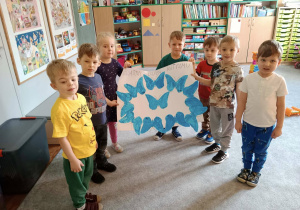 Grupa dzieci prezentująca wspólna pracę plastyczną.