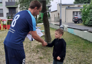 Trener wręcza dziecku dyplom
