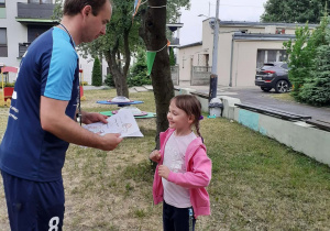 Trener wręcza dziecku dyplom