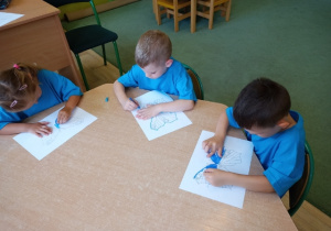 Dzieci z grupy 5 podczas kolorowania niebieskich motyli.