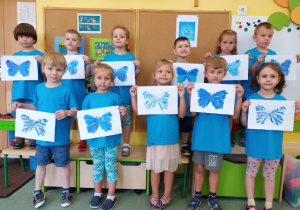 Wspólne zdjęcie dzieci z grupy 5 z wykonanymi niebieskimi motylami.