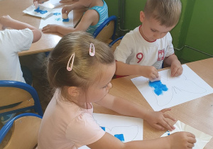 Dzieci z grupy 3 wykonują niebieskie motyle.