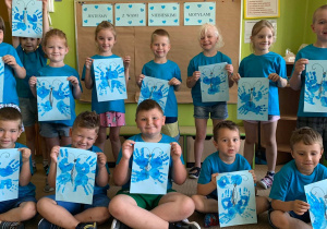 Wspólne zdjęcie dzieci z grupy 7 z wykonanymi niebieskimi motylami.
